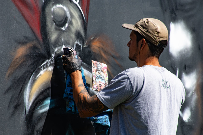 a person using spray paint on the wall
